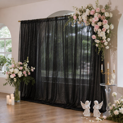 Elegant wedding arch with black sheer drapes and pink white floral arrangements