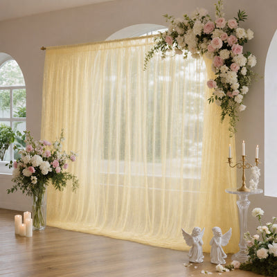 Elegant wedding backdrop with floral arches, gold curtain, and candles