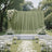 Elegant outdoor wedding ceremony setup with white floral arch and chairs
