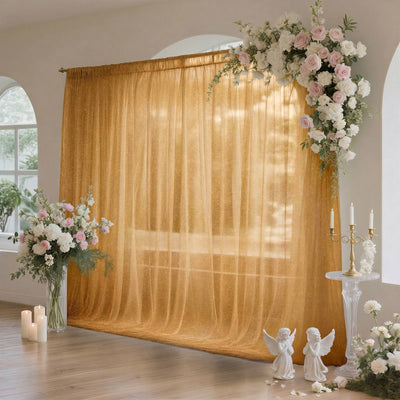Gold wedding backdrop with floral arch, candles, and angel figurines