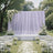 Elegant outdoor wedding ceremony setup with white floral arch and aisle petals