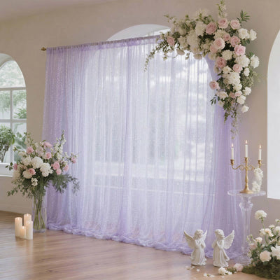 Pastel wedding backdrop with lavender drapes and floral arch
