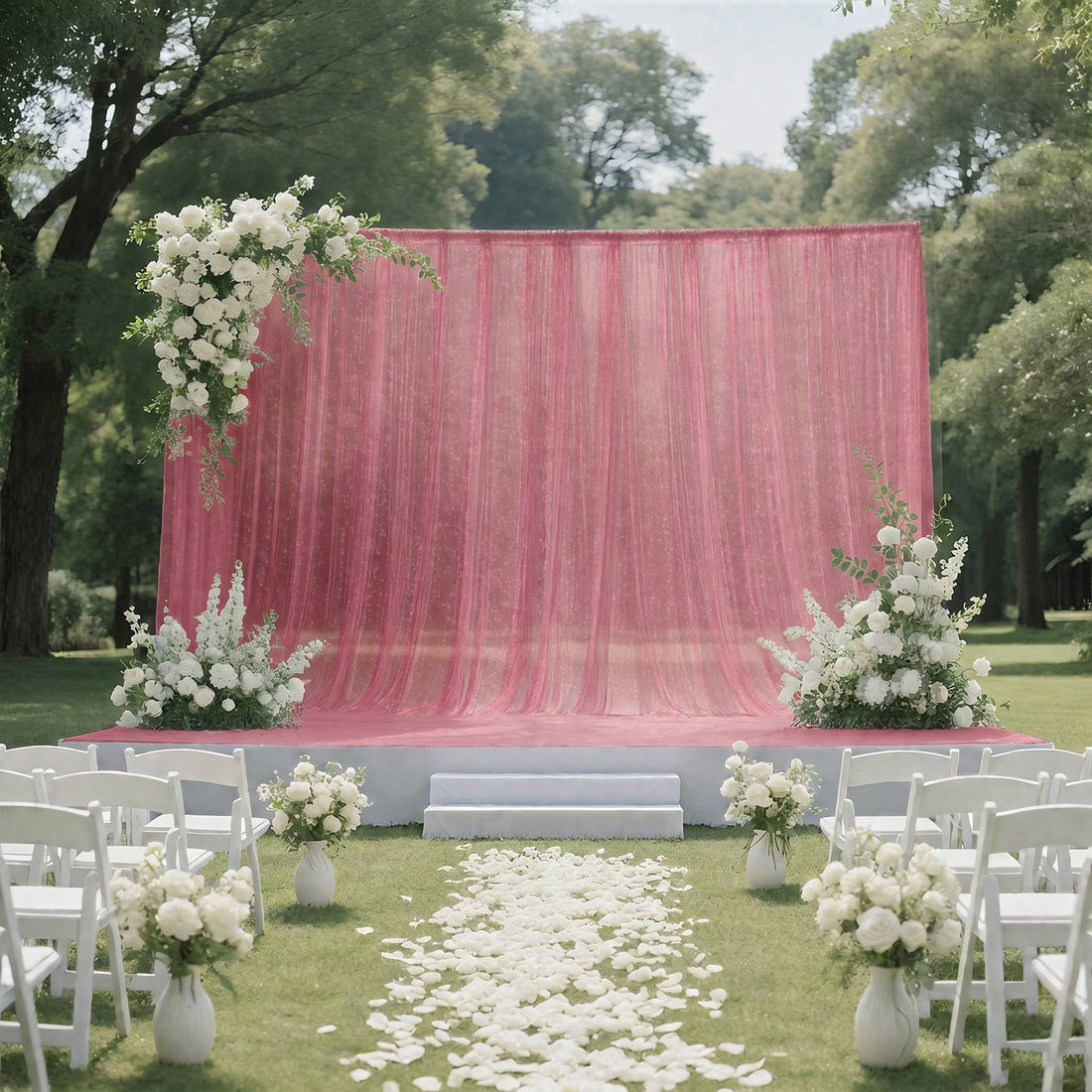 Outdoor wedding ceremony setup with pink drapery and white floral decorations