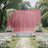 Outdoor wedding ceremony setup with pink drapery and white floral decorations