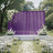 Outdoor wedding ceremony setup with purple backdrop, white flowers, and chairs