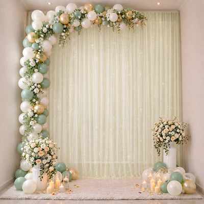 Pastel balloon and floral event backdrop with candles and white drapes