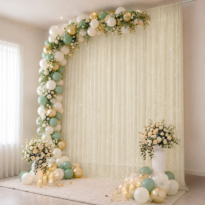 Elegant pastel balloon and floral wedding backdrop with candles and draped curtain