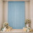 Elegant baby shower backdrop with blue curtain, floral arrangements, and pastel balloons