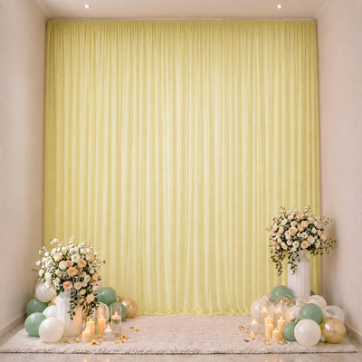 Elegant pastel wedding backdrop with floral arrangements, candles, and balloons