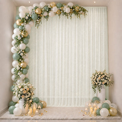Elegant mint and gold balloon floral arch with candles and white drapery backdrop