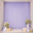 Lavender party backdrop with floral stands, balloons, and candles for celebration