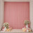 Pink party backdrop with floral arrangements, candles, and balloons in a decorated room
