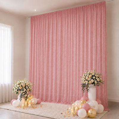 Pink birthday party backdrop with floral arrangements, candles, and balloons