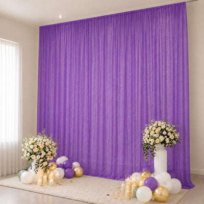 Purple party backdrop with floral arrangements, candles, and balloons