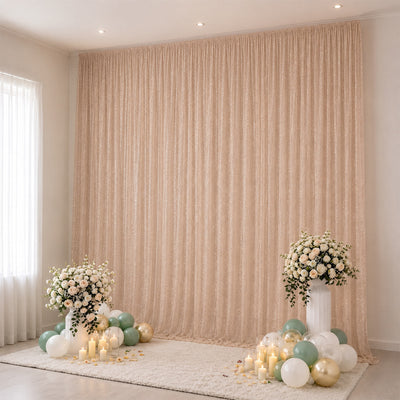 Elegant beige event backdrop with floral arrangements, candles, and pastel balloons