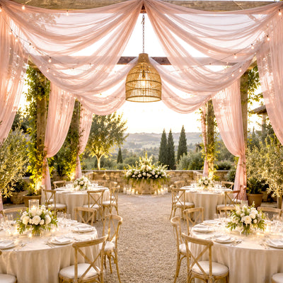Elegant outdoor wedding reception with draped pink fabric and candlelit tables