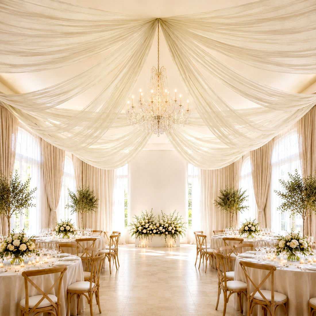 Elegant wedding reception hall with draped ceiling, chandelier, and floral tables