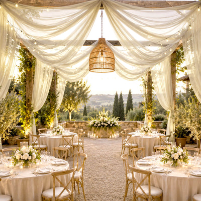 Elegant outdoor wedding reception with draped canopy and floral tablesetting