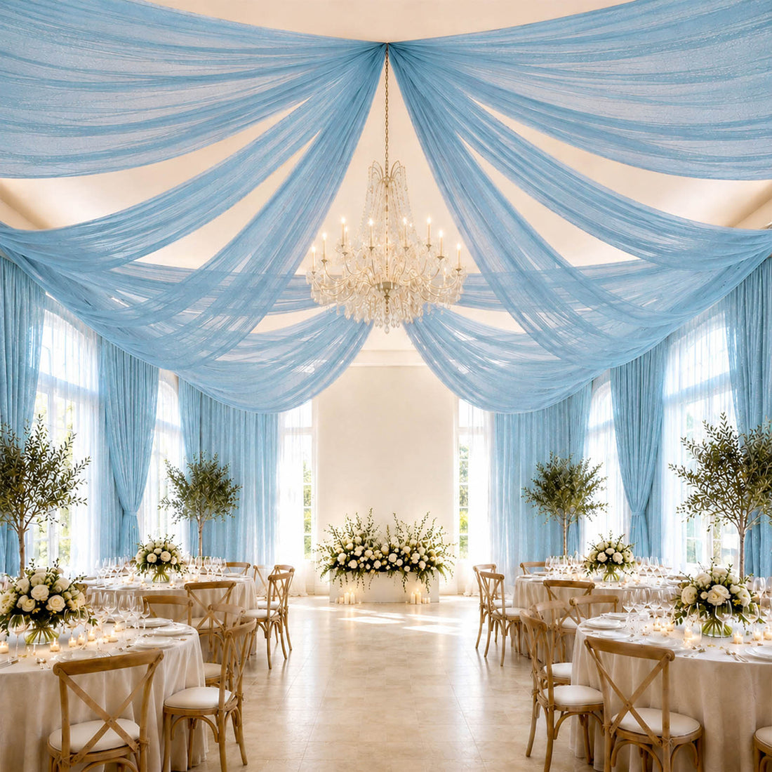 Elegant blue draped wedding reception hall with chandelier and floral tables