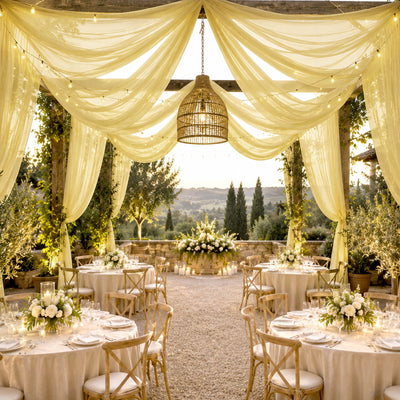 Elegant outdoor wedding reception with draped canopy, string lights, and floral tables