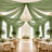 Elegant wedding reception with green drapery, chandelier, and floral tablescape
