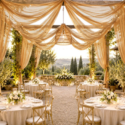Elegant outdoor wedding reception with draped canopy and sunset vineyard views