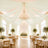 Elegant white and gold wedding reception with chandelier and floral tablescape