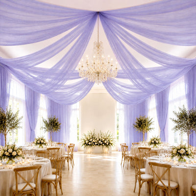 Lavender draped wedding reception with chandelier and floral tableside decor