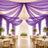 Elegant purple draped wedding reception with chandelier and floral centerpieces