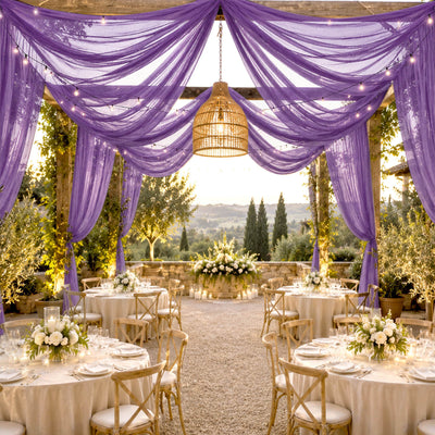 Elegant outdoor wedding reception with purple drapery, string lights, and floral tables