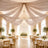 Elegant wedding reception hall with draped ceiling, chandelier, and floral tables