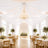 Elegant wedding reception with draped white ceiling, chandelier, and floral tables