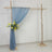 Wooden arch with blue drapery and floral arrangement for events or weddings.