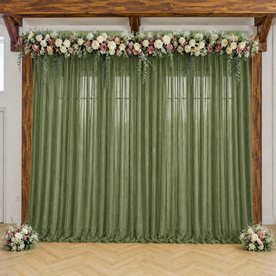 Rustic wedding backdrop with green drapes and floral garland arch