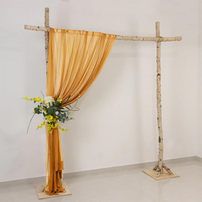 Rustic birch wedding arch with gold drape and yellow floral arrangement