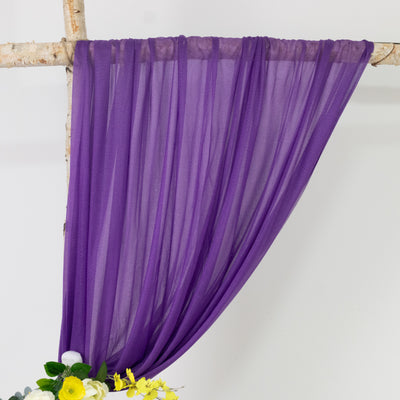 Purple sheer fabric draped elegantly on a branch with floral accents.