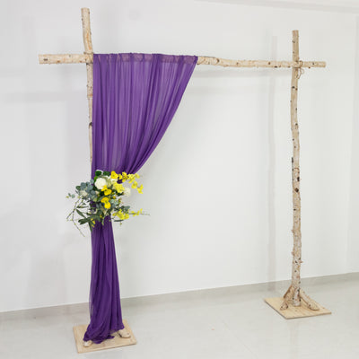 Purple drapery and floral arrangement on a rustic wooden frame