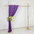 Purple drapery and floral arrangement on a rustic wooden frame