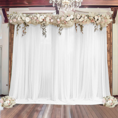 Floral backdrop with sheer white curtains and wooden accents for events or photography.
