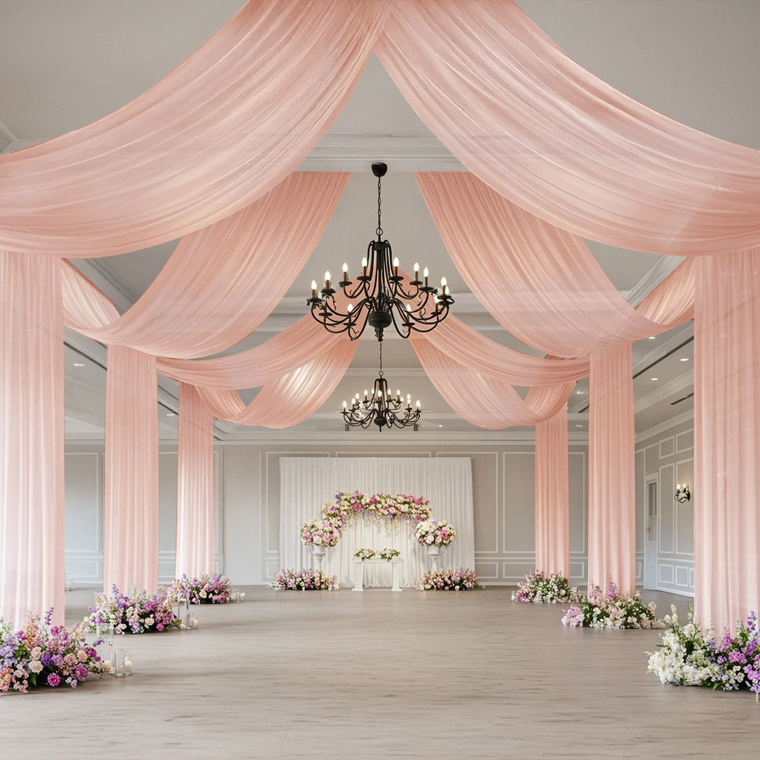 Elegant wedding venue with pink drapery and floral arrangements.