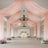 Elegant wedding venue with pink drapery and floral arrangements.