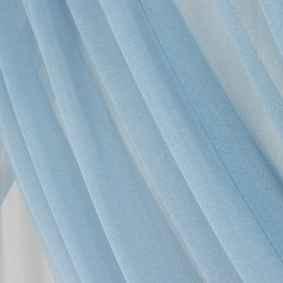 Sheer blue fabric drapes elegantly, showcasing soft texture and light flow.