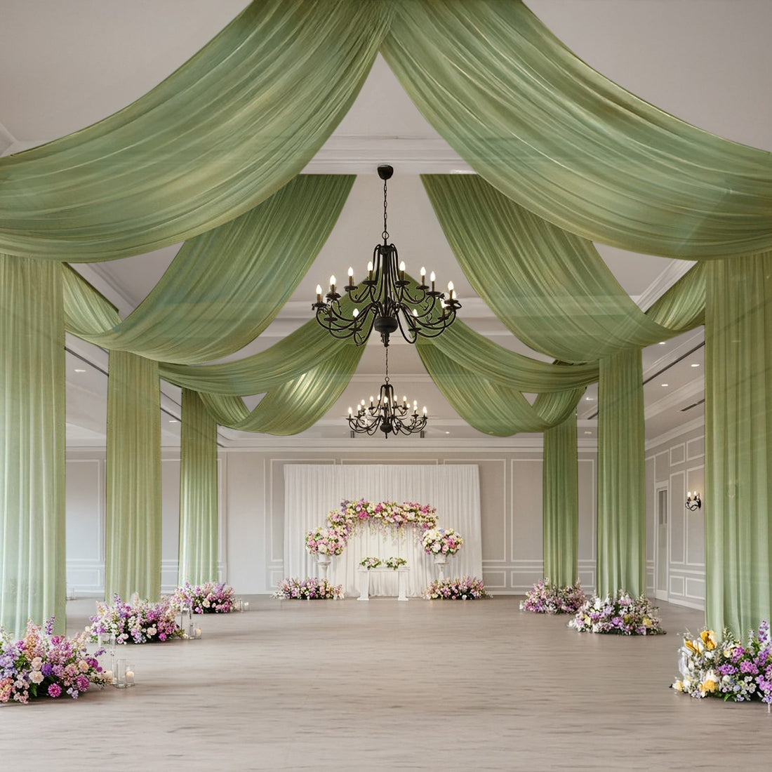 Elegant wedding venue with draped green fabric and floral arrangements.