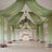 Elegant wedding venue with draped green fabric and floral arrangements.