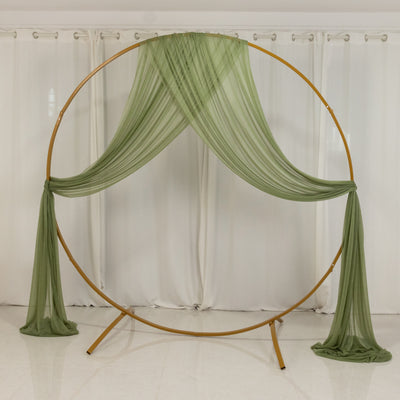 Gold circle backdrop with flowing green fabric drapes.