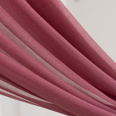 Sheer burgundy fabric draping elegantly in soft folds.