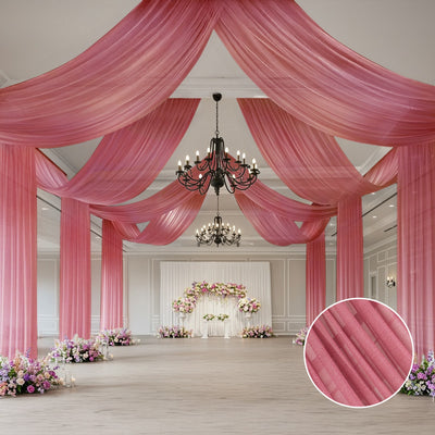 Elegant pink drapery in a decorated event space with floral arrangements.