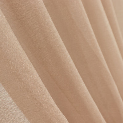 Close-up of soft, shimmering beige fabric drapes. #whtbkgd