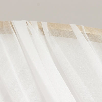 Sheer white fabric draped elegantly on a wooden surface.