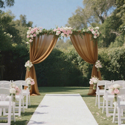 Elegant wedding arch draped in fabric, adorned with flowers, set in a lush garden.